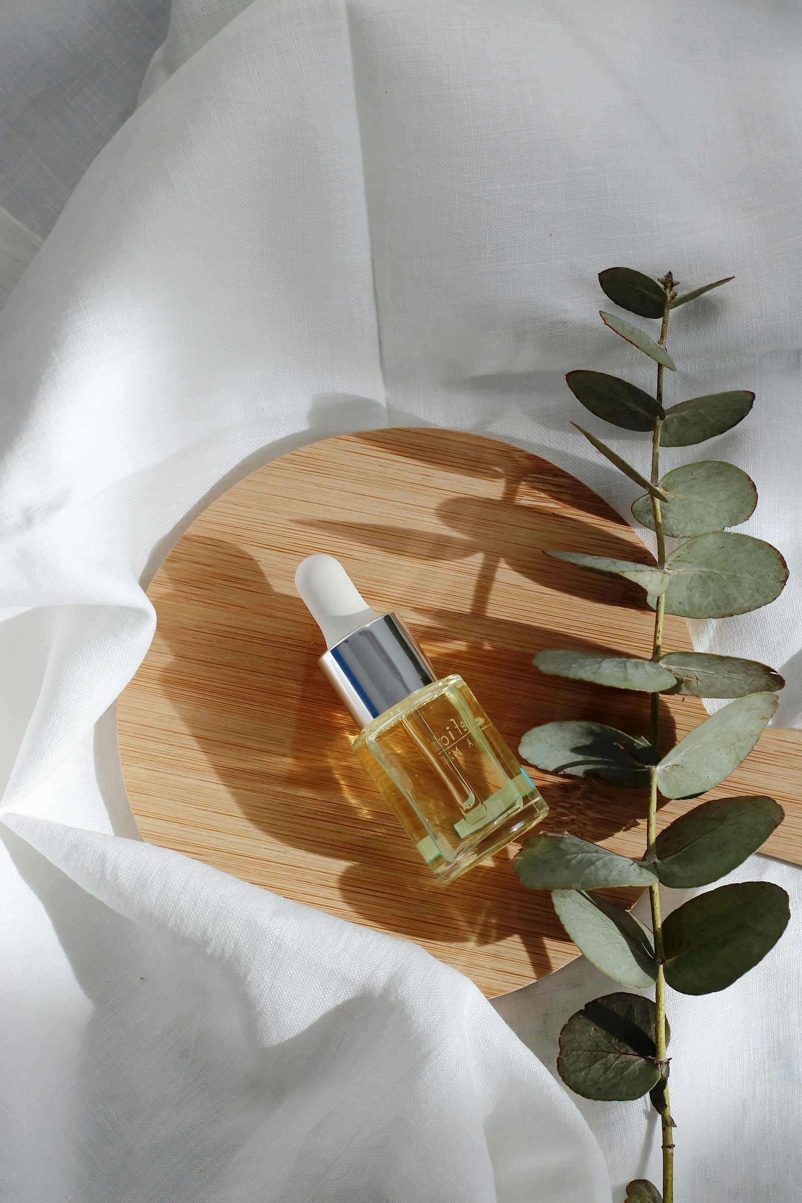 Face serum bottle on a wooden tray